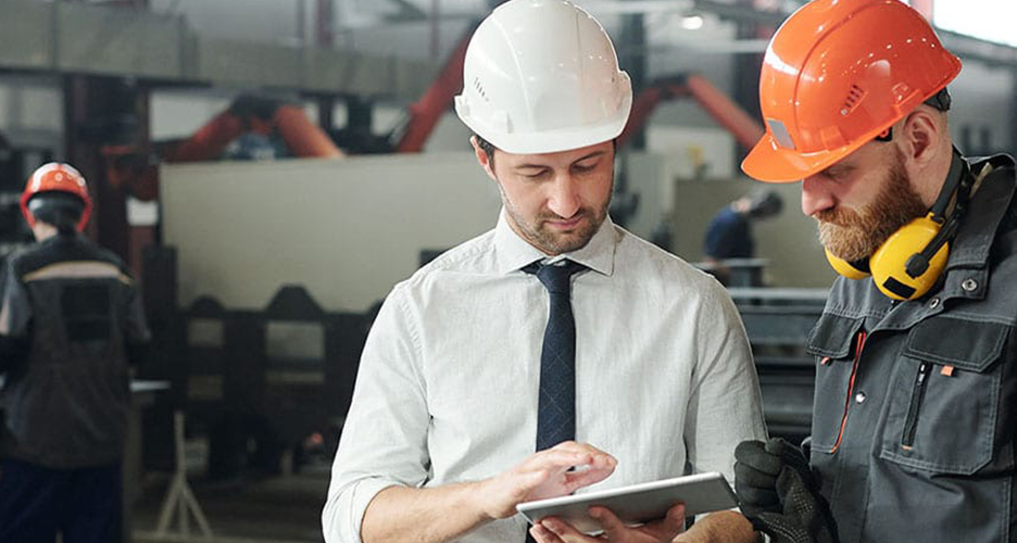 Photo of two manufacturing workers looking at a tablet computer