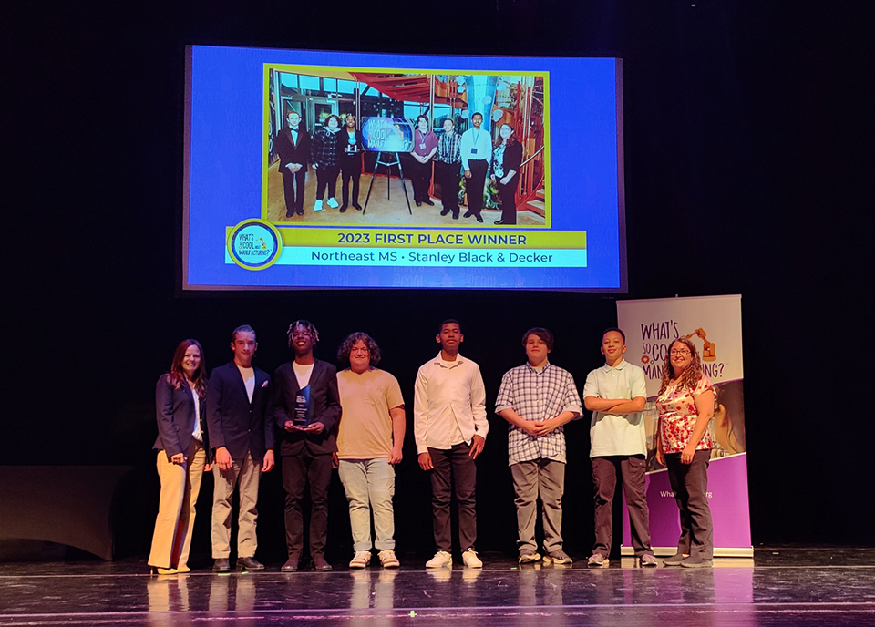 Team members and coaches from Northeast Middle School in Bethlehem, PA, posing on stage with the 2023 First Place trophy